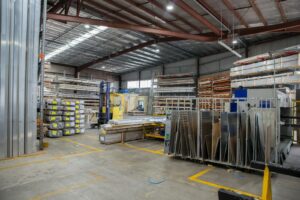 Wide view of an industrial warehouse interior showcasing stacks of steel and metal sheets.